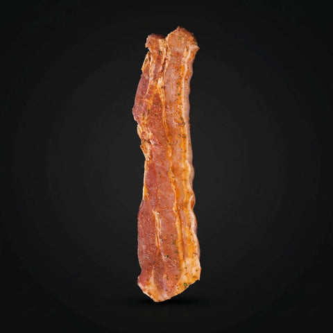 Ein Stück marinierter Schweinebauch auf schwarzem Hintergrund